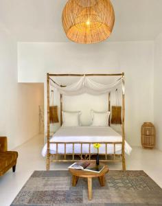 明德卢Mansa Marina Hotel的一间卧室配有一张天蓬床和一张茶几