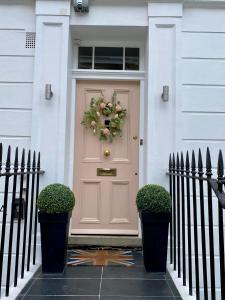 伦敦Victoria Belgravia Townhouse的房屋前门,上面有花圈