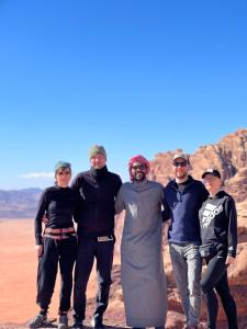 瓦迪拉姆desert colored camp的一群人在沙漠中摆出一张照片