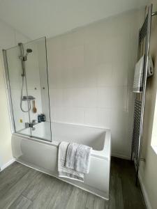 剑桥CENTRAL, newly refurb 2 bed flat with FREE PARKING的白色的浴室设有浴缸和淋浴。