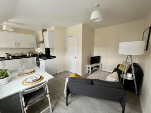 剑桥CENTRAL, newly refurb 2 bed flat with FREE PARKING的厨房以及带沙发和桌子的客厅。