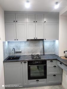 蒂拉斯波尔Lovely apartment的厨房配有白色橱柜和水槽