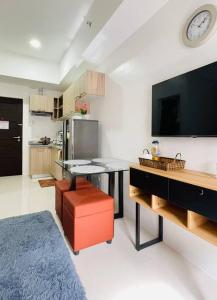 伊洛伊洛WV2 Condotel Luxury的一间厨房,内设桌子和一台电视机