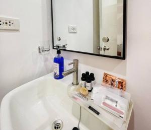 伊洛伊洛WV2 Condotel Luxury的浴室水槽,配有蓝色的肥皂和镜子