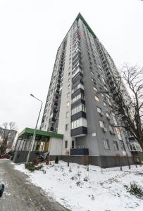 基辅Квартира студия 1 комнатная на Теремках низкий этаж的地面上积雪的高公寓楼