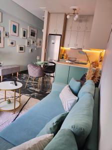 哈尔基斯Olivia Apartment-Private parking的一间带蓝色沙发的客厅和一间厨房