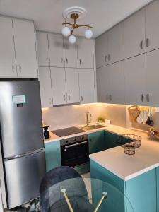 哈尔基斯Olivia Apartment-Private parking的厨房配有白色橱柜和不锈钢冰箱