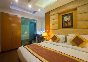新德里Hotel Palm Do'r Near New Delhi Railway Station的酒店客房配有一张床、一张桌子和一把椅子。