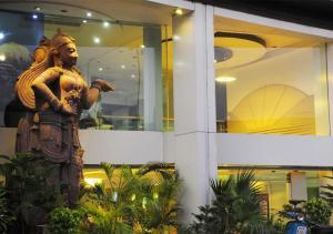 新德里Hotel Palm Do'r Near New Delhi Railway Station的建筑物前的一个人雕像