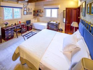 纳克萨Villa Selmunett的一间卧室配有一张大床、一张书桌和一个浴缸
