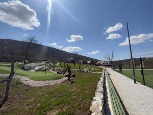 科雷尼察Plitvice Village的享有高尔夫球场和天空阳光的景色