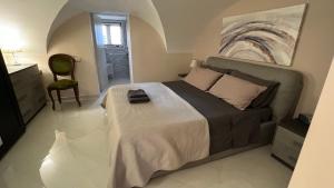 卡塔尼亚Donizetti House的一间卧室配有一张大床和一把椅子