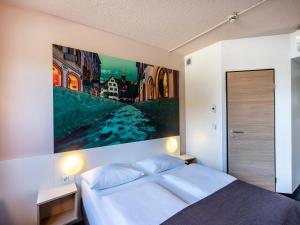 弗莱堡弗赖堡诺德早餐加住宿酒店的一间卧室配有一张壁画大床