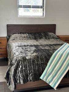 海姆维尔52 Clayton的一间卧室配有一张床铺,床上有毯子