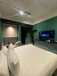 瓜拉丁加奴The Payang Hotel的卧室配有一张白色大床和一台平面电视。