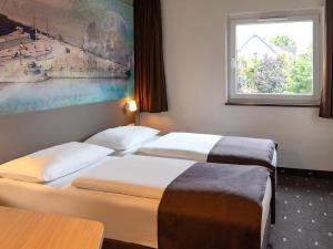 科布伦茨科布伦茨B&B酒店的配有窗户的酒店客房内的两张床
