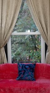 伦敦Luxury London house sleeps 13, 2 minutes to metro的窗前的红色沙发