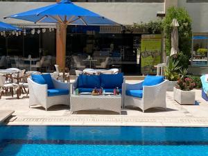 赫尔格达Rivoli Suites and Spa的一个带椅子和一张蓝伞桌子的游泳池