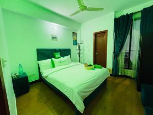 伊斯兰堡HYATT ARYANA Guesthouse 1的卧室配有一张大白色的床和风扇