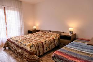 马莱斯科Casa Ezio - Piano terra的酒店客房设有两张床和窗户。