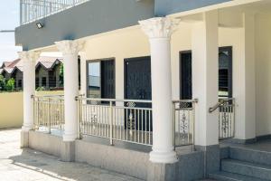KasoaPro CeDi Ventures Self-catering的一座白色柱子的建筑和一个阳台