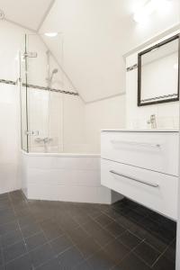 栋堡酿酒厂里的酒店的白色的浴室设有水槽和淋浴。