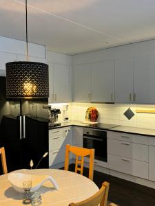 马尔默Tranquil and Convenience Southern Malmo Apartment的厨房配有白色橱柜和碗桌