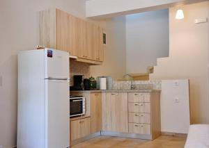 费索斯Christina's Seaside的厨房配有白色冰箱和木制橱柜。