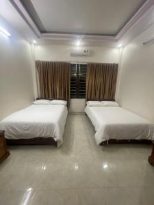 河江Holly's Hostel Ha Giang B&B的一间卧室设有两张床和窗户。