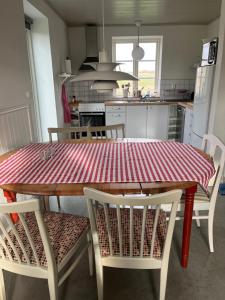 奇维克Eternellgården的厨房配有红色和白色的桌椅