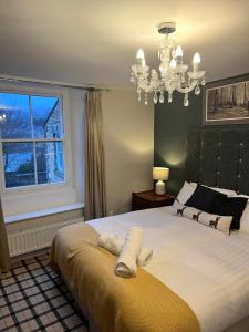 Haydon BridgeThe Railway Hotel的一间卧室配有一张带吊灯和窗户的床。
