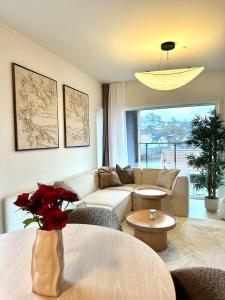 桑内斯Nydelig perle rett ved fjorden的客厅配有沙发和玫瑰桌