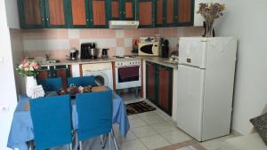 帕拉代西翁老屋酒店的厨房配有带蓝色椅子的桌子和冰箱。