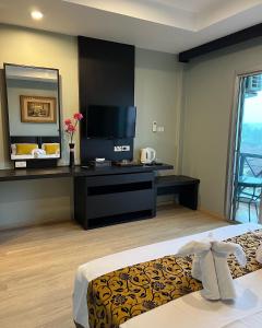卡塔海滩Aloha Residence的酒店客房,配有床和电视