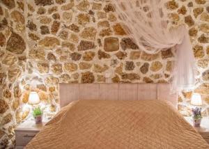 阿齐欧斯·贡多斯Bungalow nefeli的一间卧室设有石墙和床