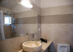 阿齐欧斯·贡多斯Bungalow nefeli的一间带石质水槽和淋浴的浴室