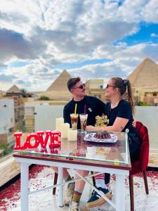 开罗Locanda pyramids view的坐在桌子上的男人和女人,带着蛋糕