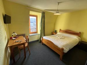 米拉AUX GLOBE-TROTTERS的一间卧室配有一张床、一张桌子和一个窗户。