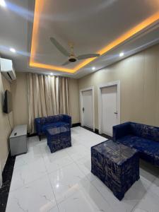 KhāriānKharian-Inn Hotel的客厅设有蓝色的沙发和天花板