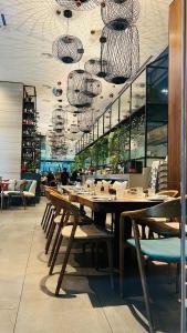 吉隆坡Crystal Suite at Dorsett Bukit Bintang KL的餐厅设有长桌、椅子和吊灯