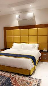 塔伊夫HOLIDAy فاملي الطائف的一间卧室配有一张带黄色床头板的大床