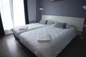 拉盖里尼耶尔迪娜努瓦尔穆捷酒店的配有2张床的带白色床单和枕头的客房