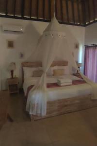 乌鲁瓦图Alamanda Bingin的一间卧室配有一张带蚊帐的床