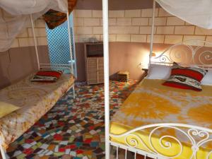 PoponguineCampement Baobab的配有两张床铺的客房,铺有马赛克地板