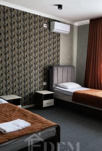 塔拉兹ЭДЕМ的酒店客房,设有两张床和两张桌子