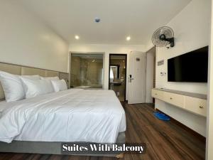 河内Grand Dragon Noi Bai Hotel的卧室配有一张大白色床和平面电视