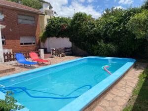 马德普拉塔Santa Cruz 5761的一个带两把椅子的庭院内的游泳池