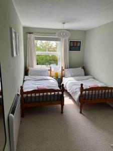 奇切斯特Bright flat in the heart of Chichester的卧室设有两张床,带窗户