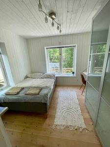 DalaröHärlig Skärgårdsvilla med strålande sjöutsikt的一间带床的卧室,位于带窗户的房间内