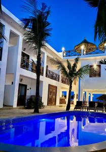 蓬圭Karibu Beach Resort的夜间带游泳池的别墅